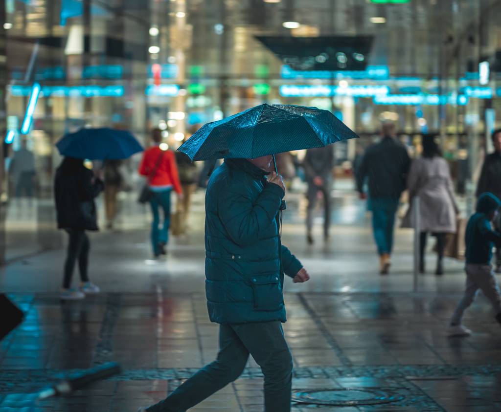 MUNICH, ALEMANHA - 01 de fevereiro de 2020: Pessoas atravessando a rua durante uma noite chuvosa em Munique. Luzes de néon iluminando a cena. Tráfego urbano em segundo plano
. - Foto, Imagem