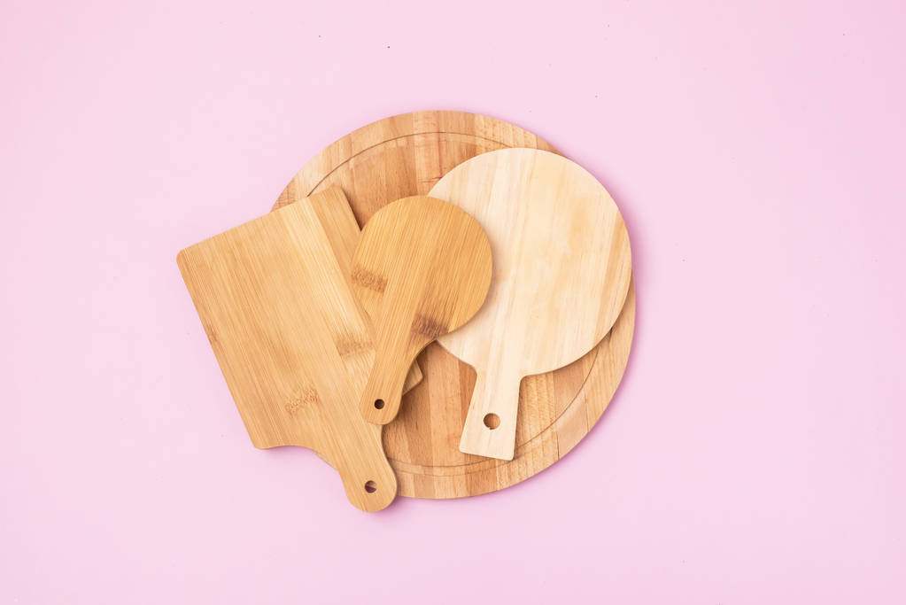 Variedad de tablero de corte circular multifuncional de madera para cortar o servir fondo rosa Vista superior
 - Foto, imagen