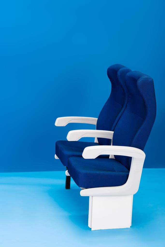 heldere en kleurrijke stoelen op blauwe achtergrond met kopieerruimte - Foto, afbeelding
