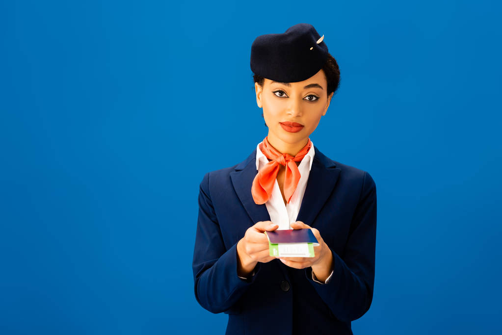 афроамериканський льотчик тримає паспорт і авіаквиток ізольовано на синьому
  - Фото, зображення