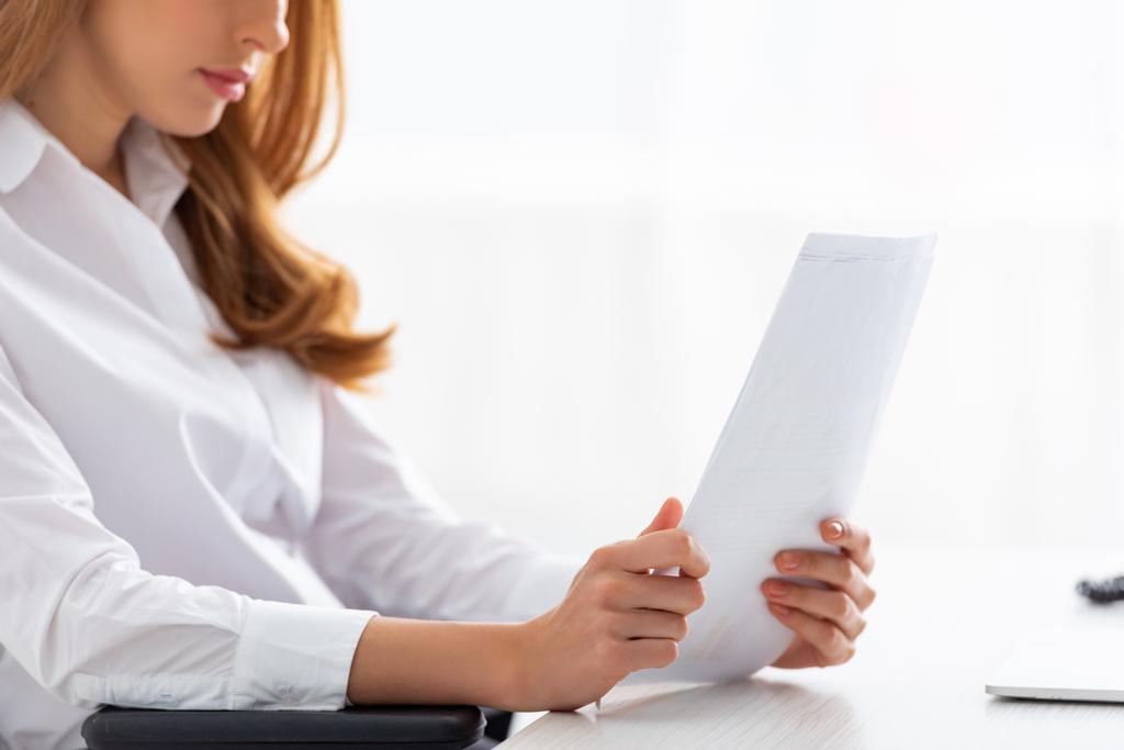 Widok bizneswoman trzymających papiery z wykresami przy stole - Zdjęcie, obraz