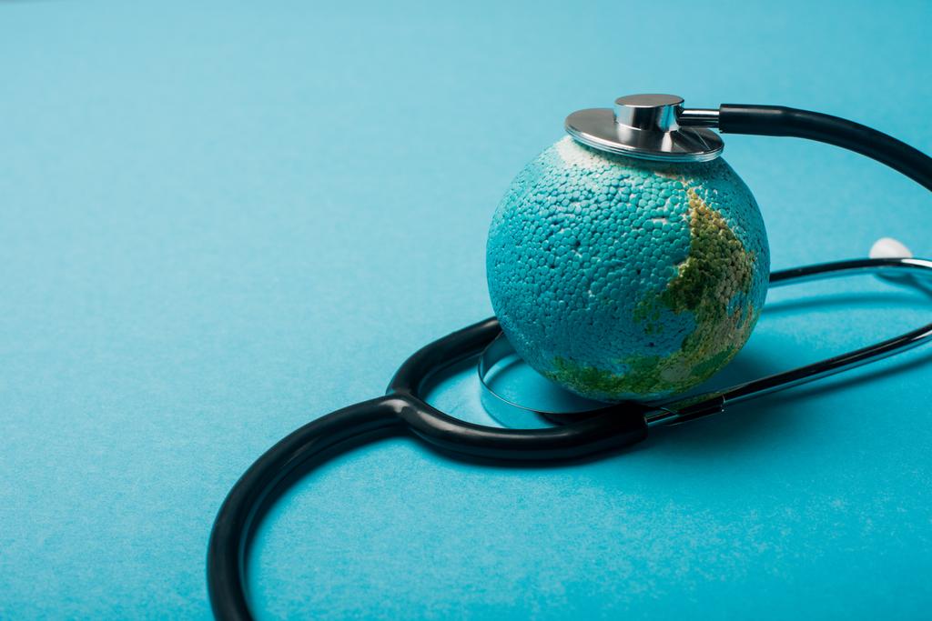 Steteskop mavi arkaplandaki dünyayla bağlantılı, dünya sağlık günü konsepti - Fotoğraf, Görsel