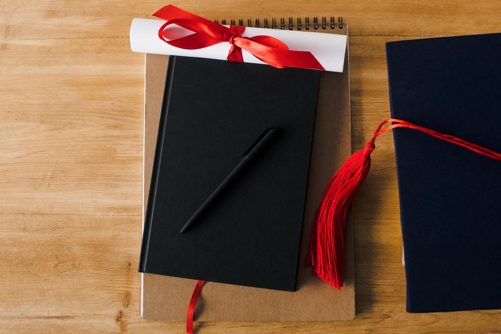 Вид зверху на блокноти, ручку, диплом і червону масу на дерев'яному фоні
 - Фото, зображення