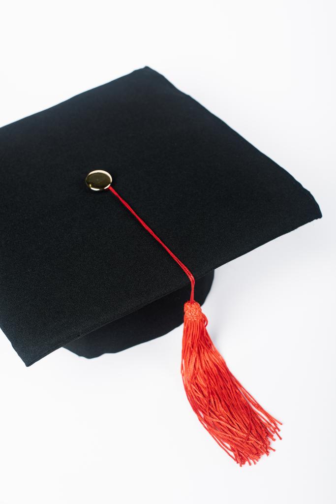 Μαύρο καπέλο αποφοίτησης με κόκκινη φούντα απομονωμένο σε λευκό - Φωτογραφία, εικόνα