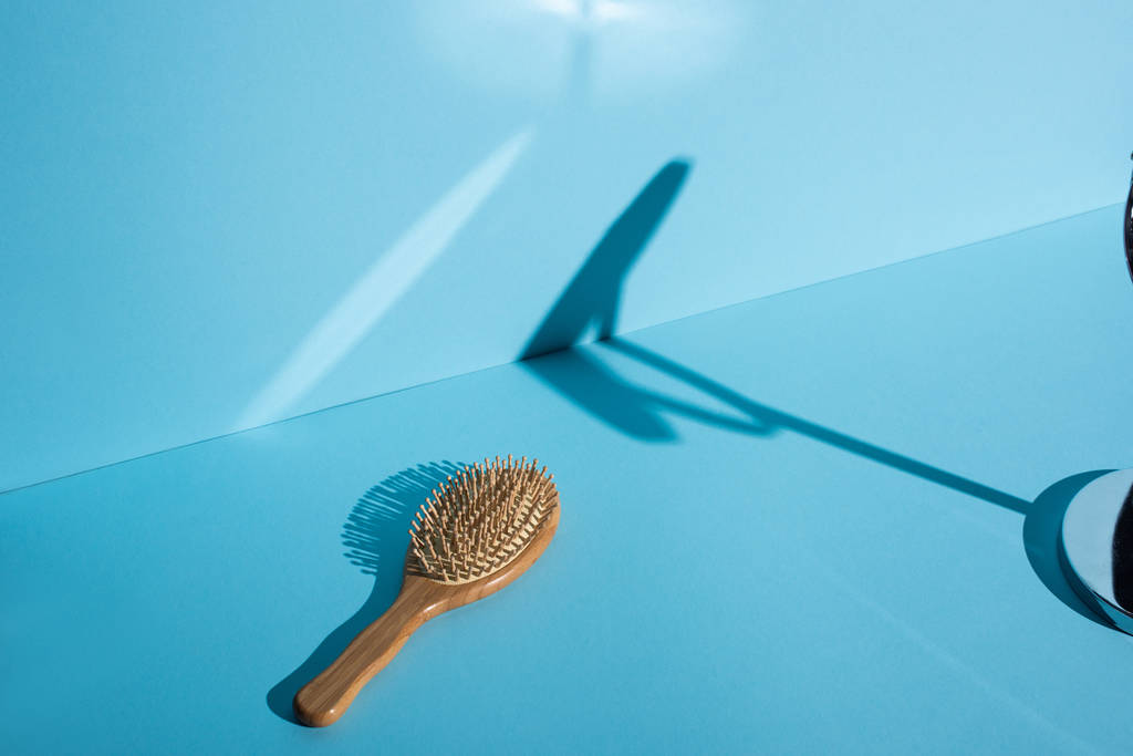 Деревянная щетка для волос и тень на синем фоне, нулевая концепция отходов
 - Фото, изображение