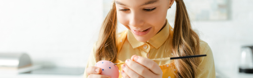 tiro panorámico de niño feliz pintando huevo de Pascua con pincel
  - Foto, imagen