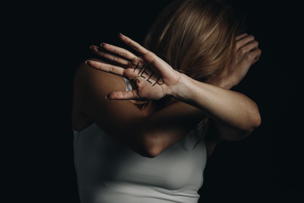 Slachtoffer verbergen en tonen palm met behulp van letters geïsoleerd op zwart  - Foto, afbeelding