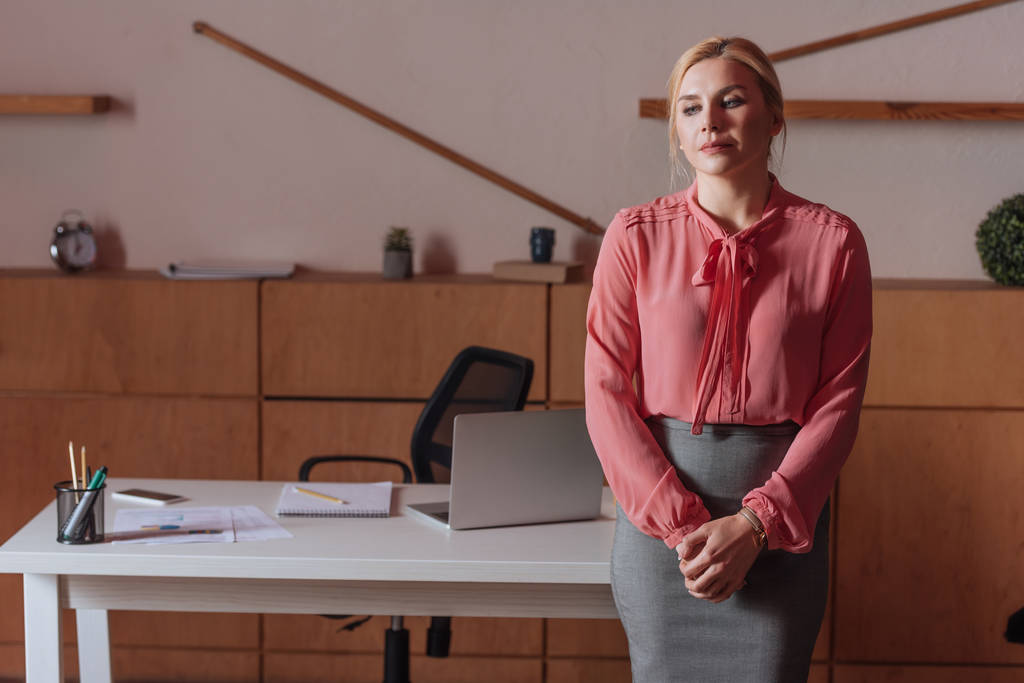 Вид женщины, стоящей за столом в офисе
 - Фото, изображение
