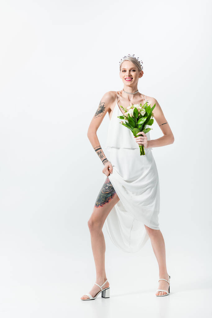 gelukkig mooi getatoeëerd bruid met boeket op wit - Foto, afbeelding