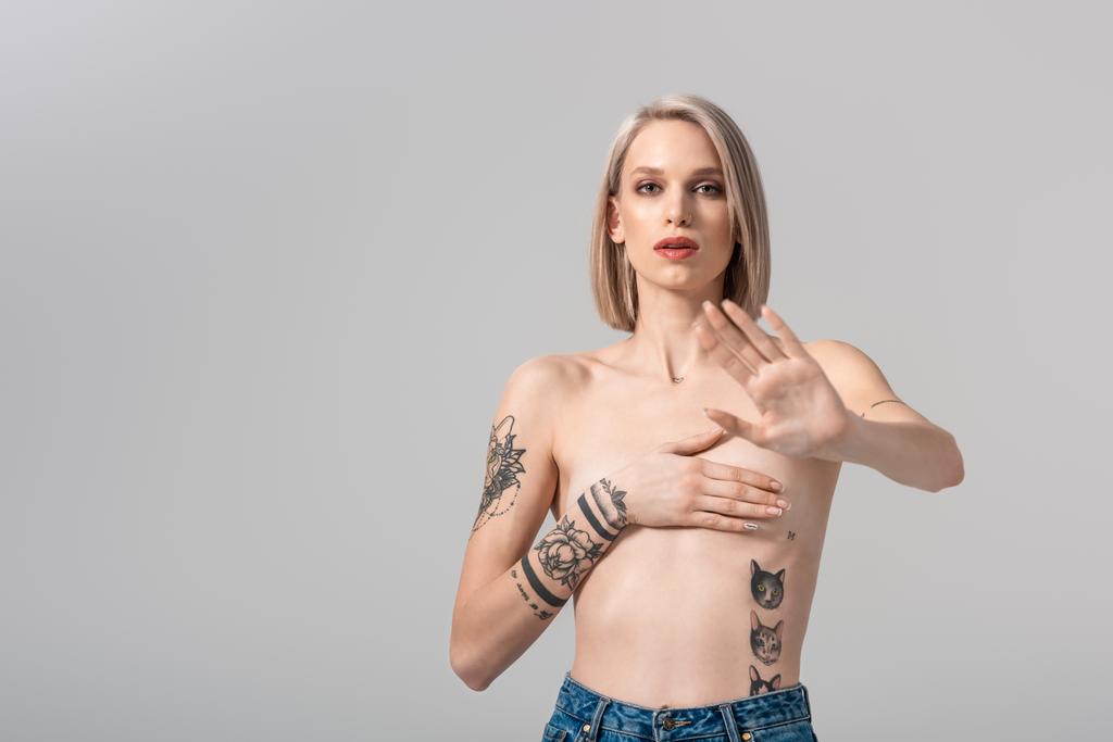 sexy jeune femme tatouée seins nus ne montrant aucun geste isolé sur gris
 - Photo, image