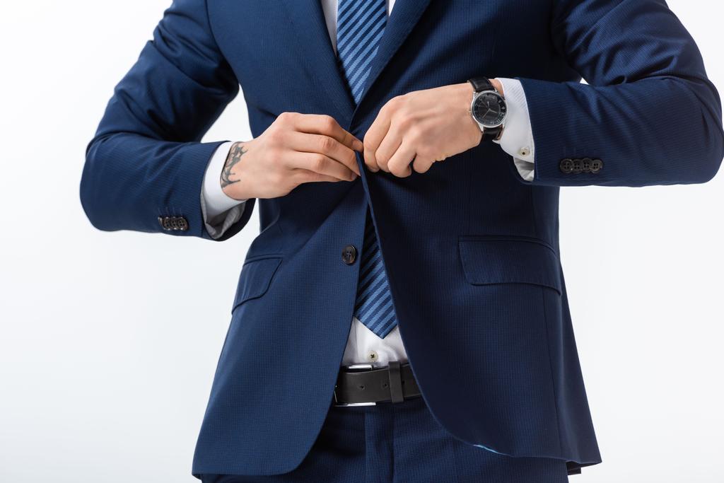 vue recadrée de succès tatoué jeune homme d'affaires en costume bleu boutonnage blazer isolé sur blanc
 - Photo, image