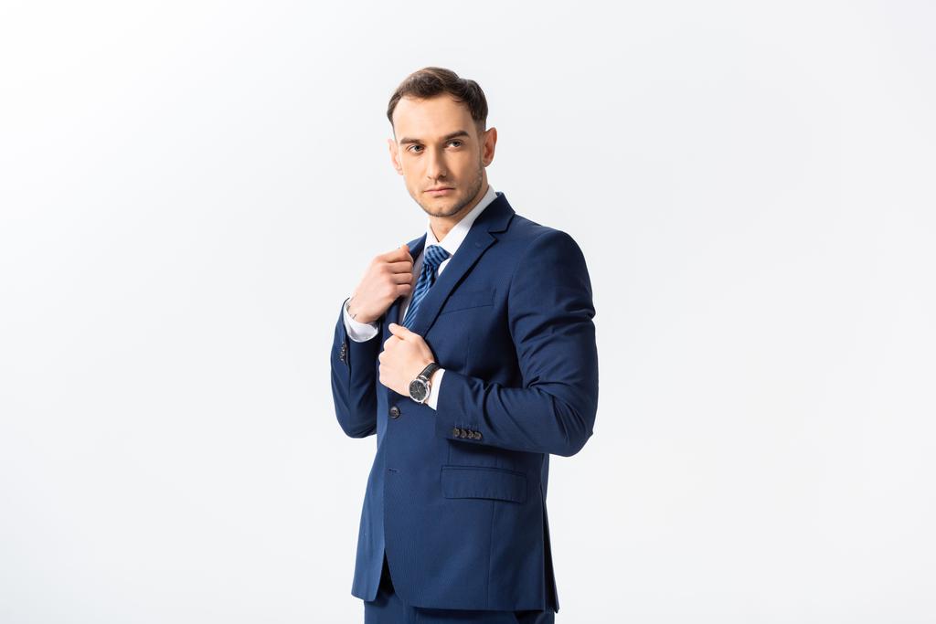 Erfolgreicher junger Geschäftsmann im blauen Anzug, der isoliert auf Weiß blickt - Foto, Bild