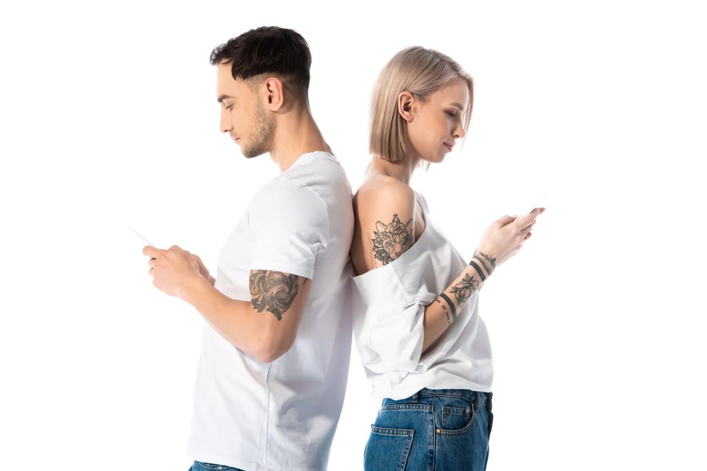 jeune couple tatoué à l'aide de smartphones tout en se tenant dos à dos isolé sur blanc
 - Photo, image