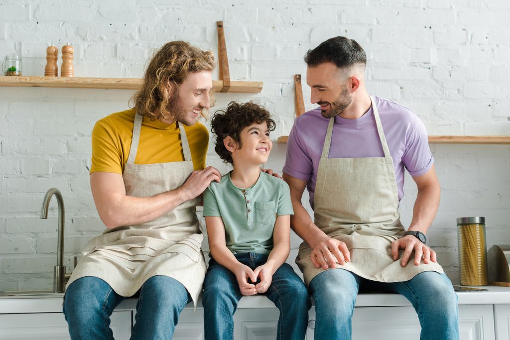 Selektiver Fokus glücklicher homosexueller Eltern auf Sohn mit gemischter Rasse  - Foto, Bild