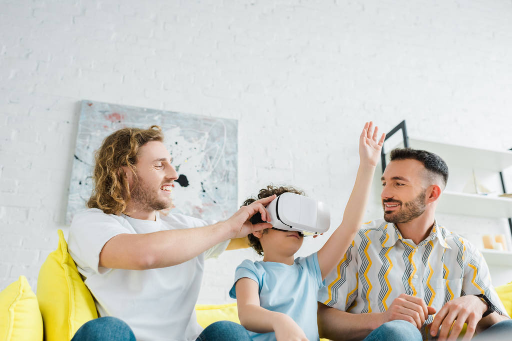 ευτυχείς ομοφυλόφιλοι γονείς κοντά μικτή φυλή γιος στην εικονική πραγματικότητα headset  - Φωτογραφία, εικόνα