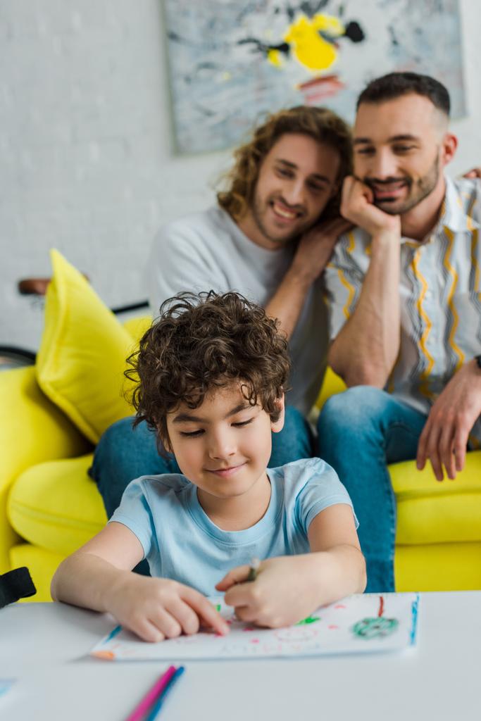 selective focus of happy mixed race kid drawing near homosexual parents  - Photo, Image