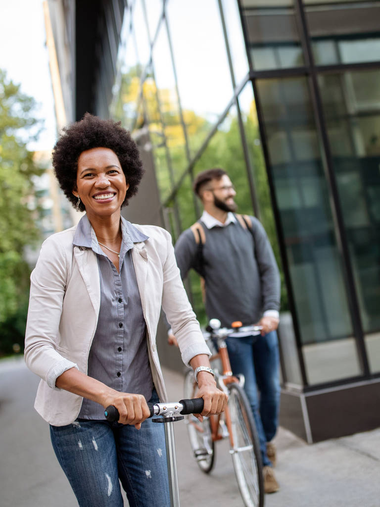 Casal interracial feliz usando scooter elétrico, bicicleta na cidade. Conceito de energia ecológica verde com emissão zero - Foto, Imagem