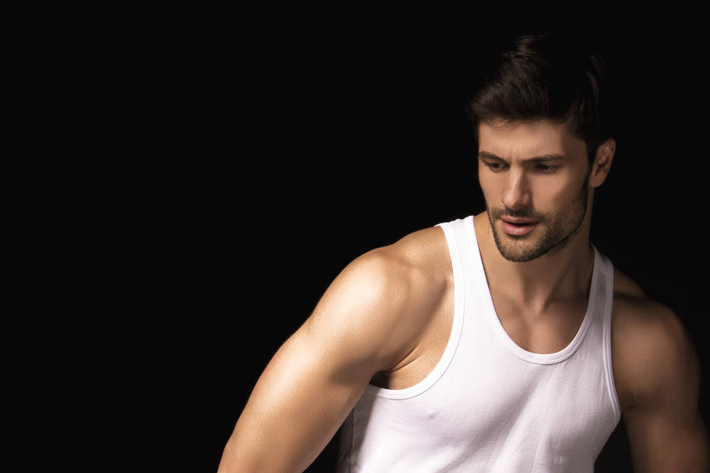 Músculo forte belo modelo masculino despojado com camisa branca em jeans cinza jeans em preto isolado fonte fundo
 - Foto, Imagem