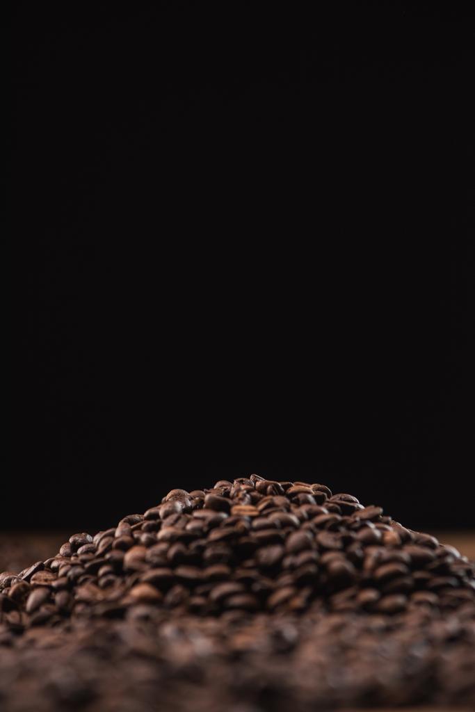 selective focus of roasted coffee beans in pile isolated on black - Photo, Image