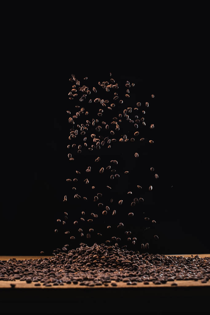 torrado grãos de café em pilha e no ar isolado em preto
 - Foto, Imagem