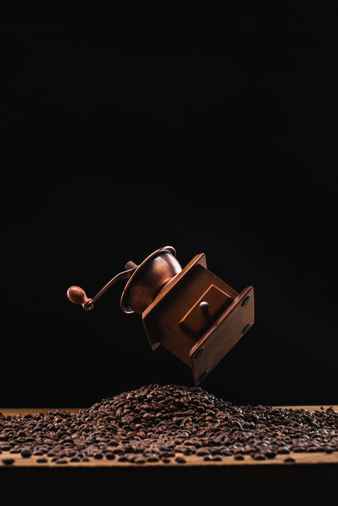 moulin à café au-dessus des grains de café torréfiés frais isolés sur noir
 - Photo, image