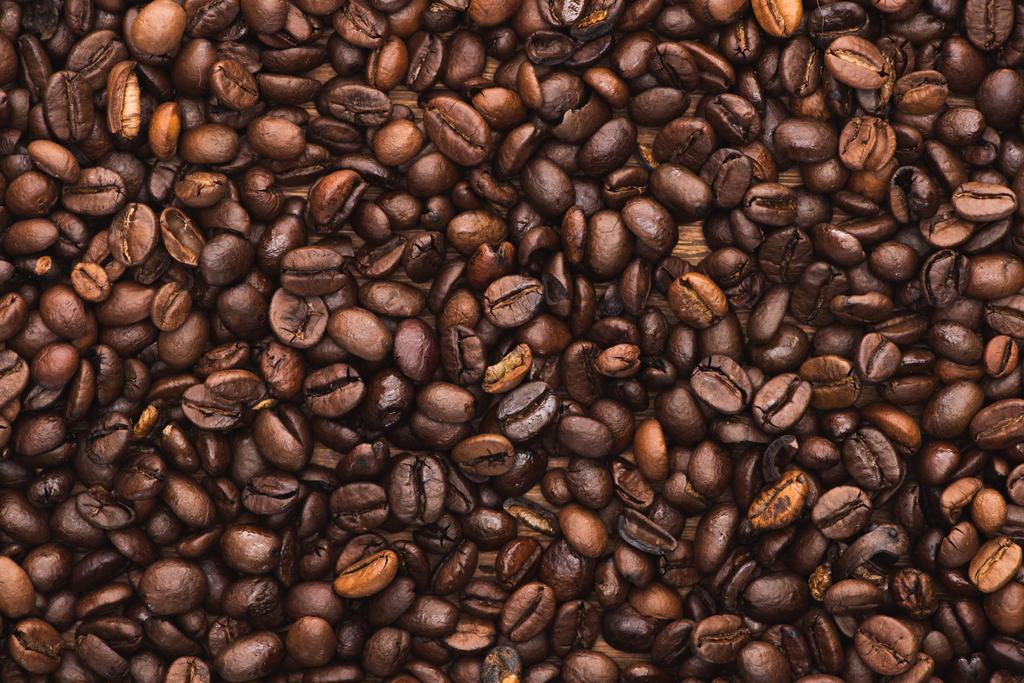 Draufsicht auf frisch geröstete Kaffeebohnen Hintergrund - Foto, Bild
