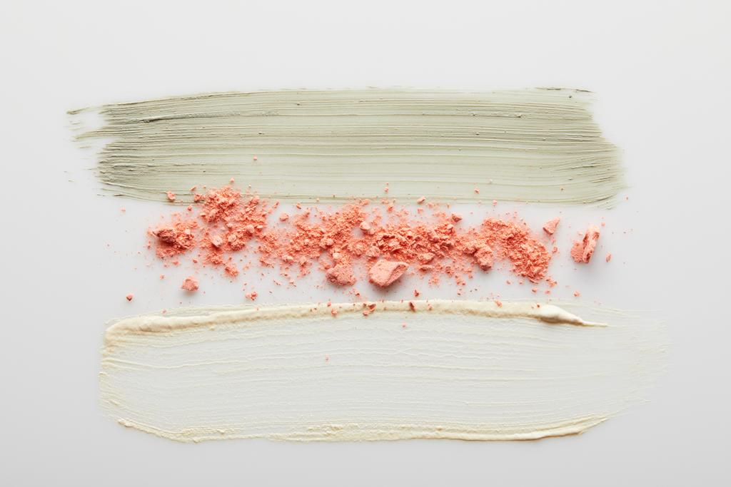 Vista superior de pinceladas de creme de argila e tom cosmético com blusher em fundo cinza
 - Foto, Imagem