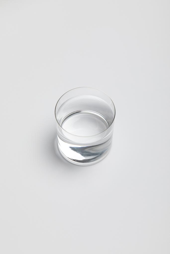 transparentní sklenice sladké vody na bílém povrchu - Fotografie, Obrázek