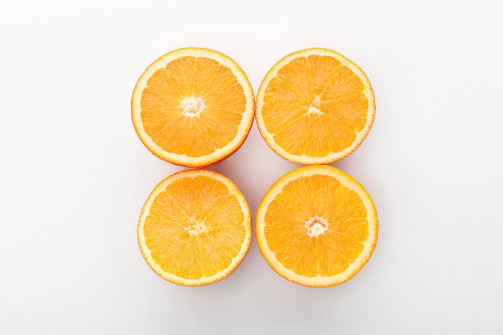 Beyaz arkaplanda kesilmiş portakalların üst görünümü - Fotoğraf, Görsel