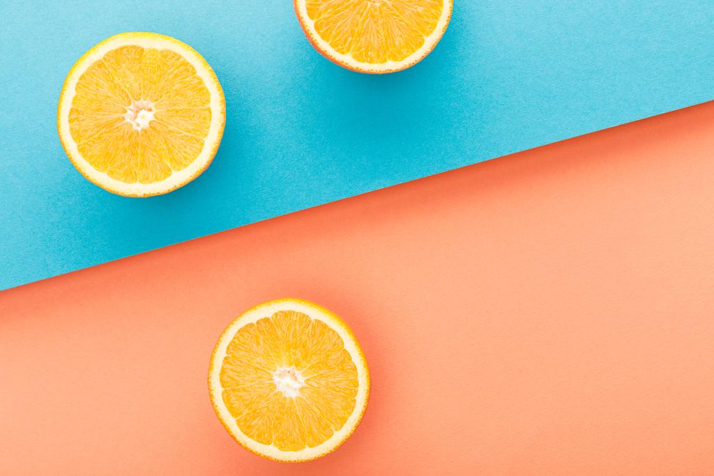Верхний вид апельсинов на голубом и оранжевом фоне
 - Фото, изображение