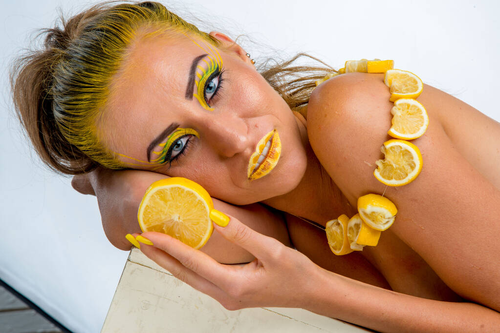 krásná dívka se žlutými vlasy a plátkem citronu - Fotografie, Obrázek