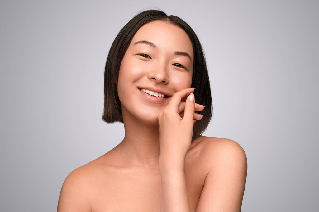 Счастливая китаянка наслаждается мягкостью кожи
 - Фото, изображение