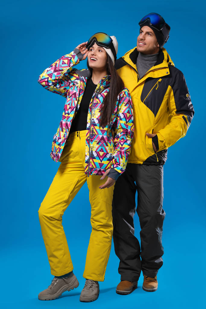 Açık mavi sırtında şık kış sporu giysileri giyen çift. - Fotoğraf, Görsel