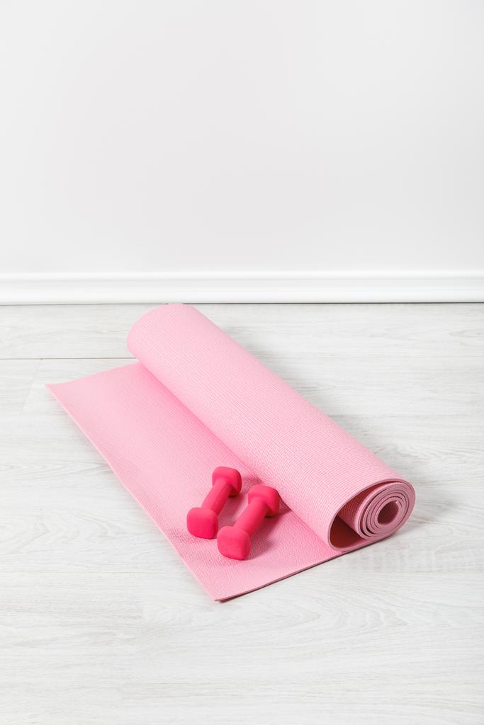 pink fitness mat and dumbbells on white floor - Photo, Image