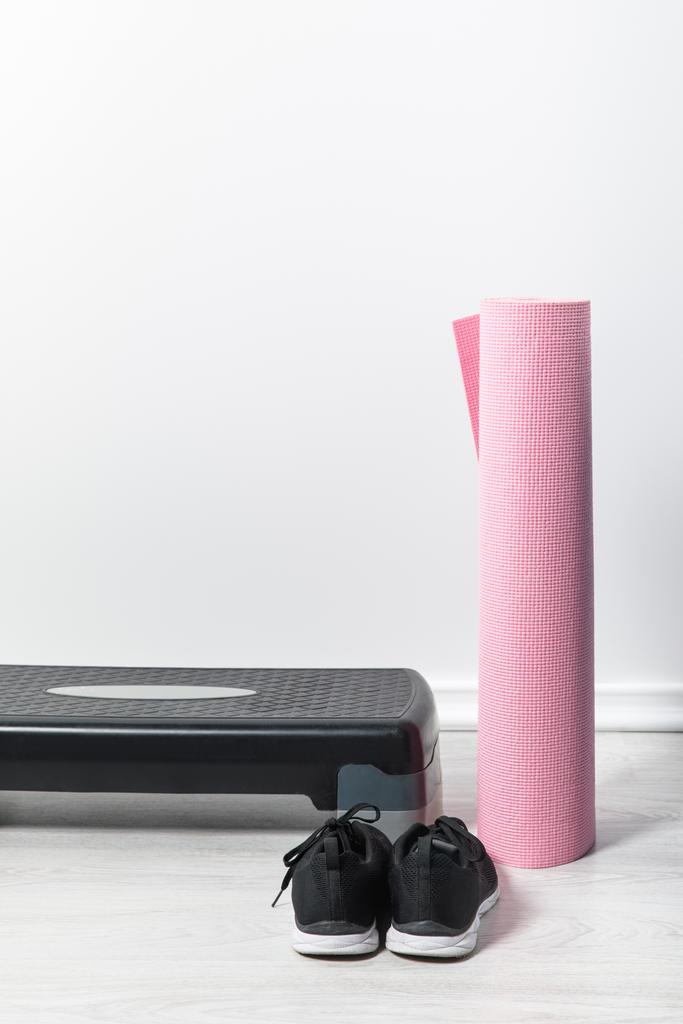 platforma krokowa, różowa mata fitness i trampki na podłodze w domu  - Zdjęcie, obraz