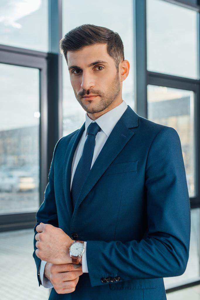 красивый профессиональный бизнесмен в костюме, позирующий в современном офисе
 - Фото, изображение