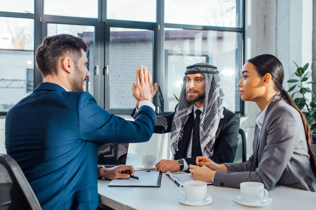 позитивные мультикультурные деловые партнеры дали высокую оценку встрече с переводчиком в офисе
  - Фото, изображение