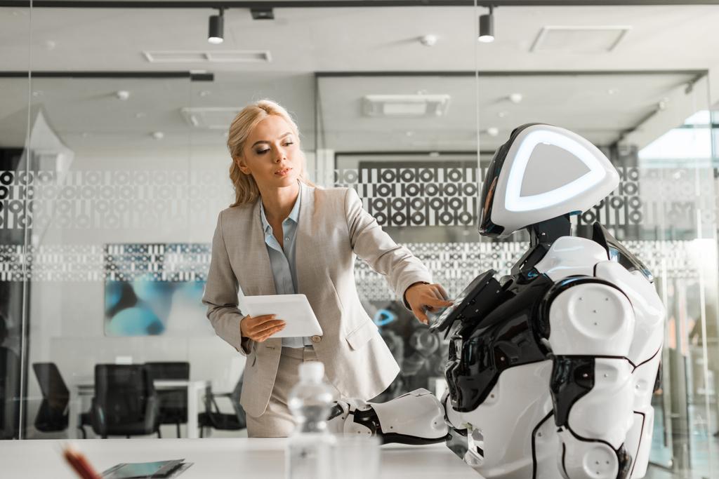 atraktivní podnikatelka držící digitální tablet při ovládání robota - Fotografie, Obrázek