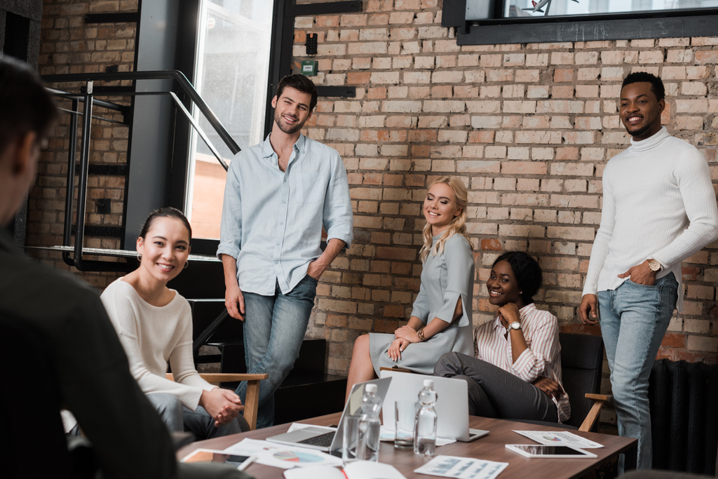junge multikulturelle Geschäftsleute lächeln während eines Treffens im Amt - Foto, Bild