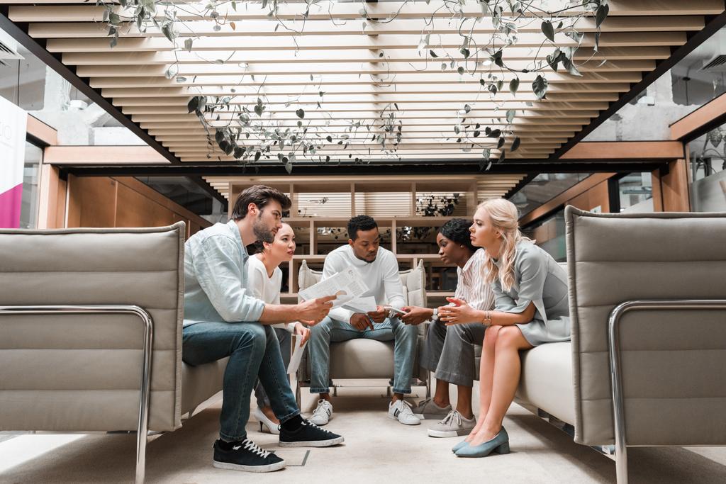 fiatal multikulturális üzletemberek ülnek irodai társalgóban találkozó közben - Fotó, kép
