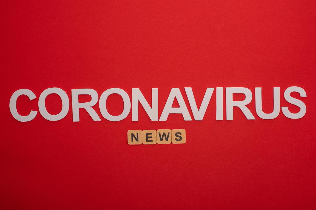 Top kilátás szó hírek fából készült kockák és koronavírus felirat a piros háttér - Fotó, kép