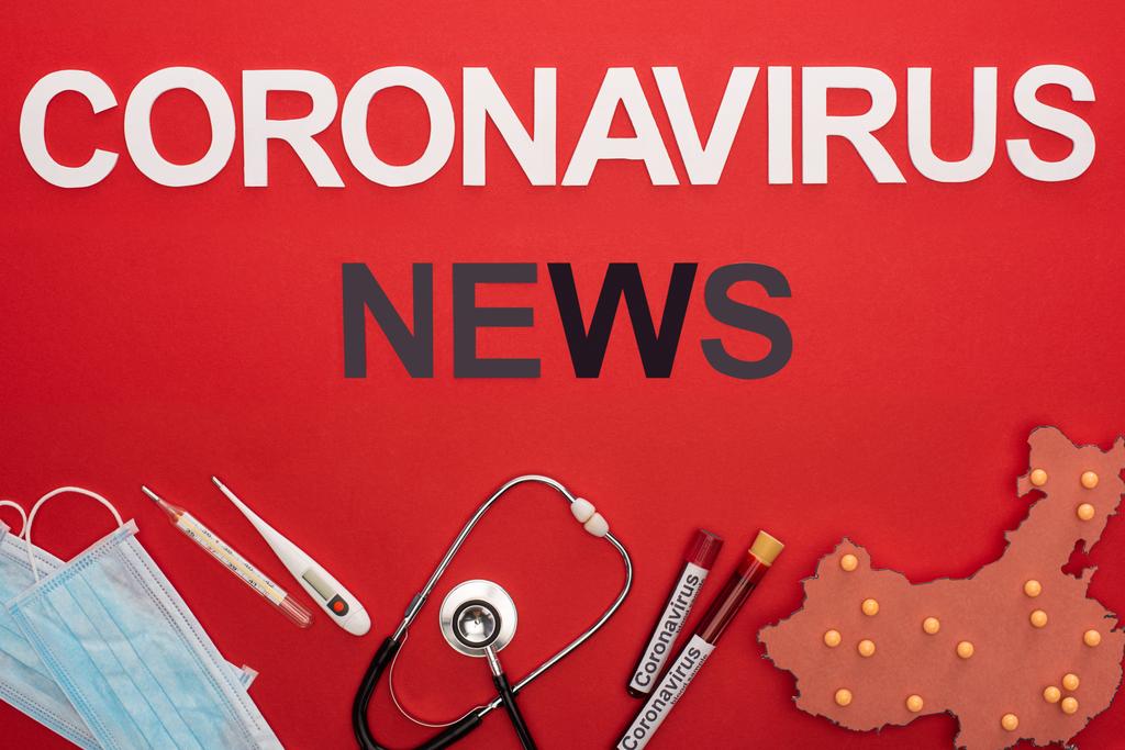 Top kilátás a koronavírus hírlevél orvosi berendezések és elrendezés porcelán térkép piros felületen - Fotó, kép