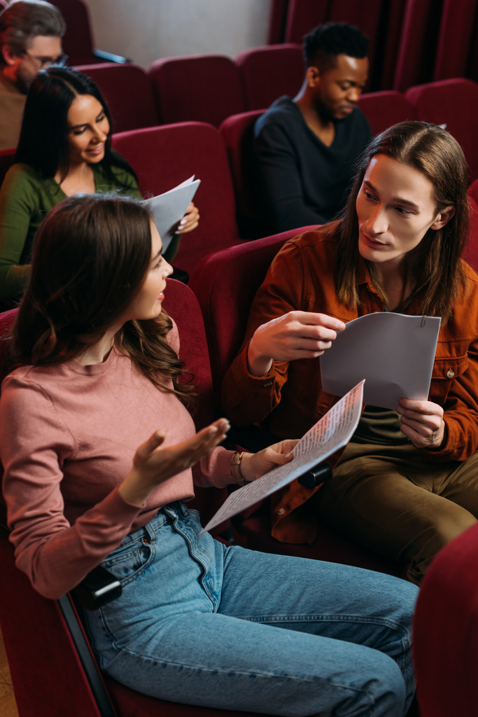 mladí multikulturní herci a herečky čtou scénáře na sedadlech v divadle - Fotografie, Obrázek