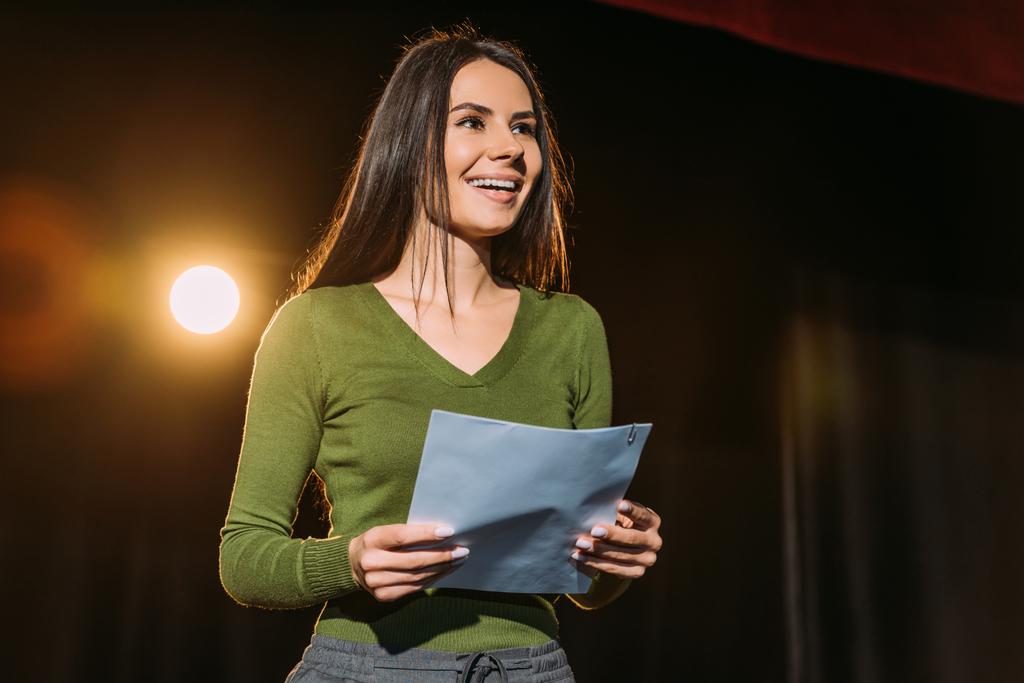 actriz alegre interpretando el papel con el guion en el escenario en el teatro
 - Foto, imagen