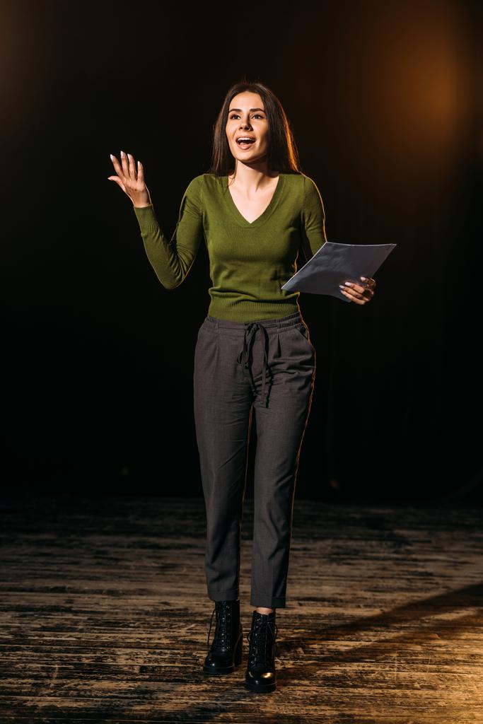 συναισθηματική ηθοποιός παίζει ρόλο με το σενάριο επί σκηνής στο θέατρο - Φωτογραφία, εικόνα