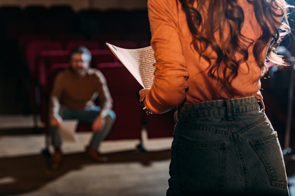 selectieve focus van theaterregisseur en actrice met scenario op het podium - Foto, afbeelding
