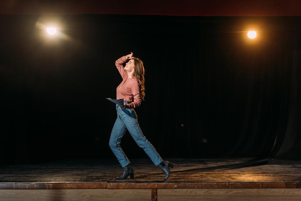емоційна молода актриса виконує роль на сцені театру
 - Фото, зображення