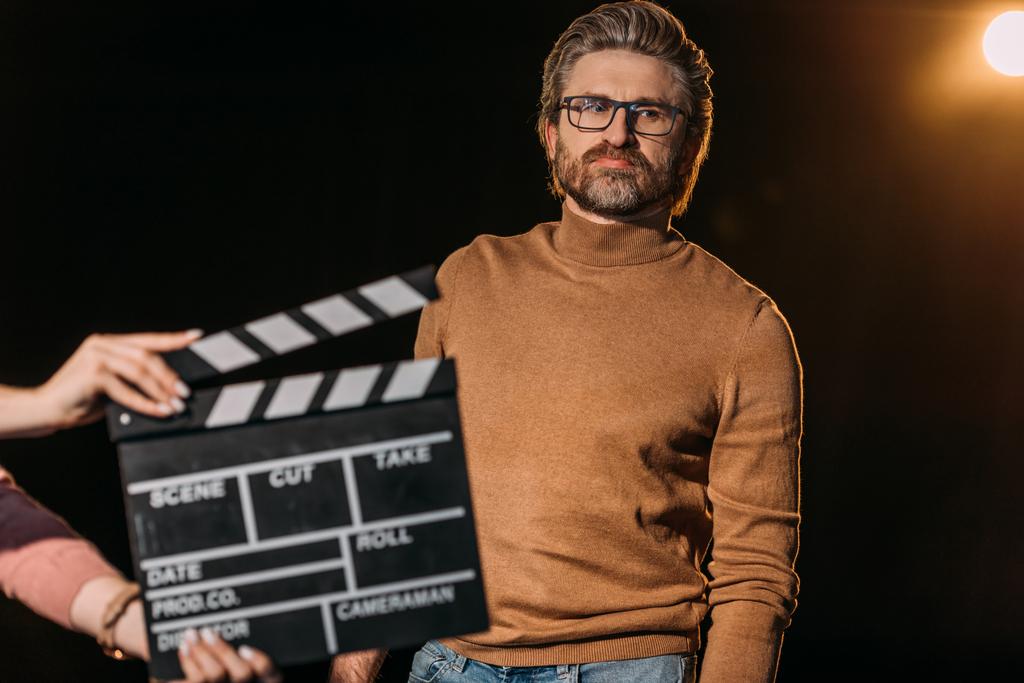 selective focus of mature actor with clapboard in front  - Photo, Image