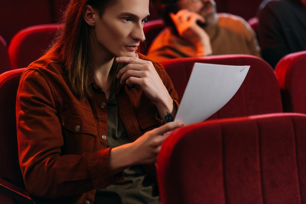selectieve focus van twee acteurs die scripts lezen terwijl ze in het theater zitten - Foto, afbeelding