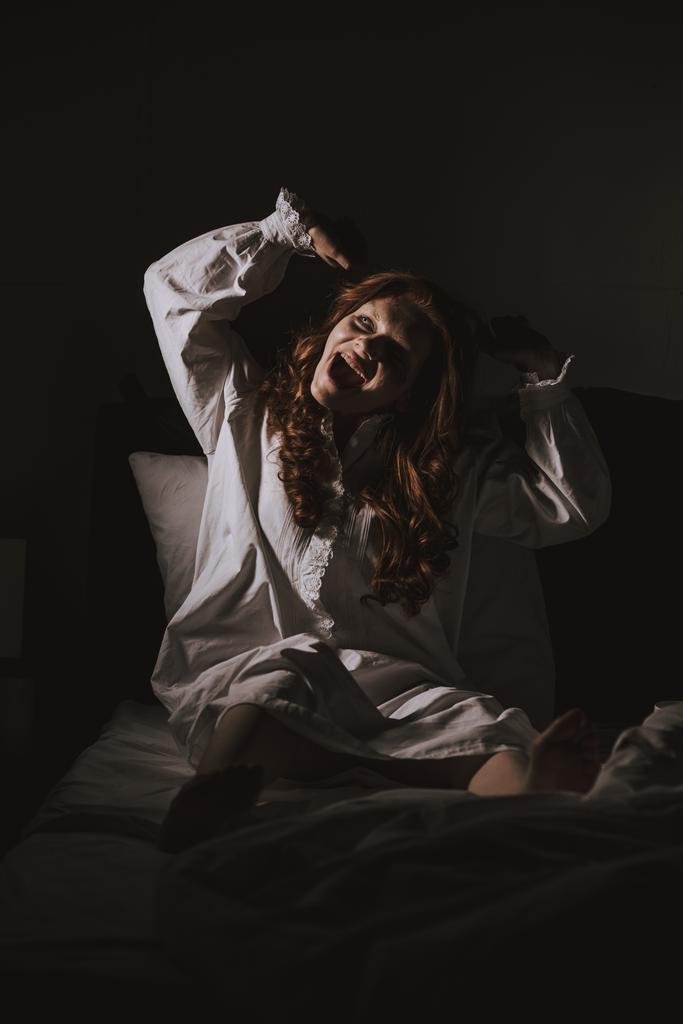 Паранормальные жуткая девушка в ночной рубашке кричать в постели
 - Фото, изображение